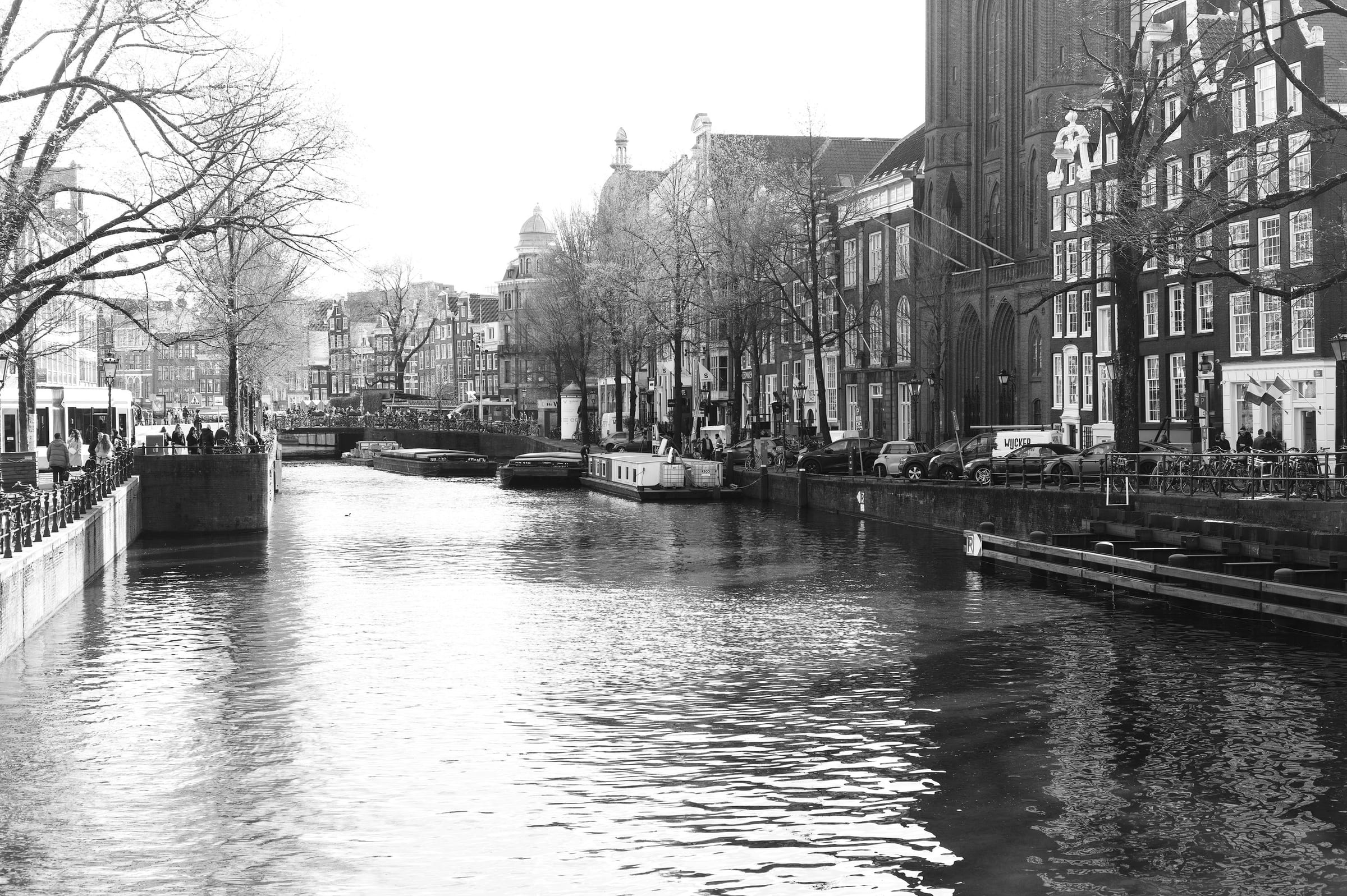 Blick über eine Gracht mit Hausbooten und Giebelhäusern